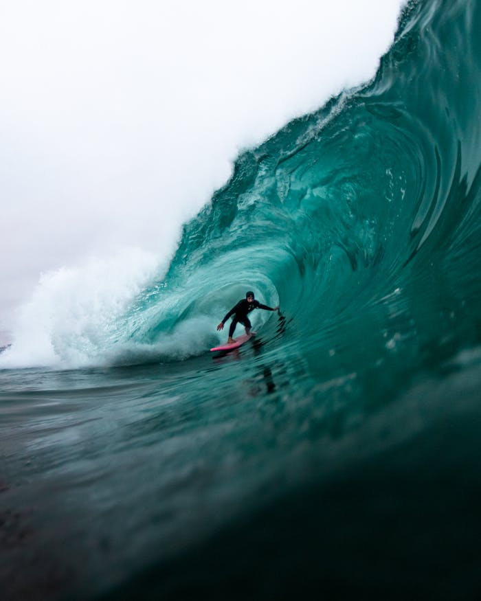 Surfer riding a massive wave, showcasing dynamic water movement and extreme sports action.